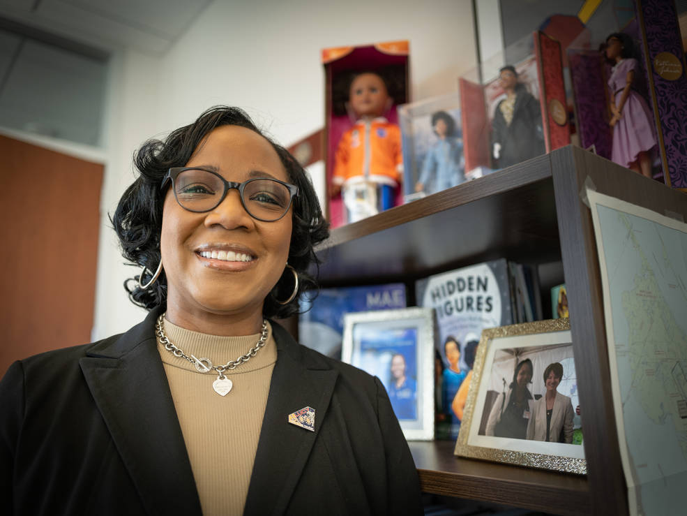 Donya Douglas-Bradshaw smiles are the camera, her desk behind her.