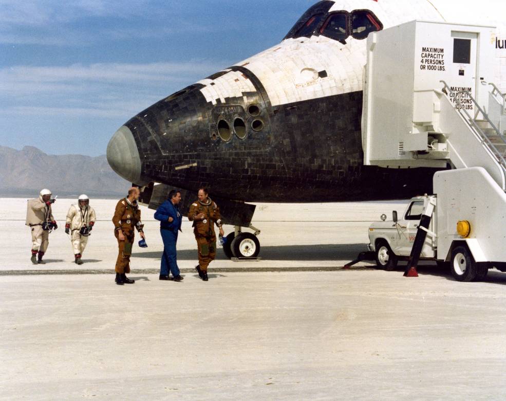 Fullerton, left, and Lousma perform the traditional walkaround of Columbia with Director of Flight Operations George W.S. Abbey.