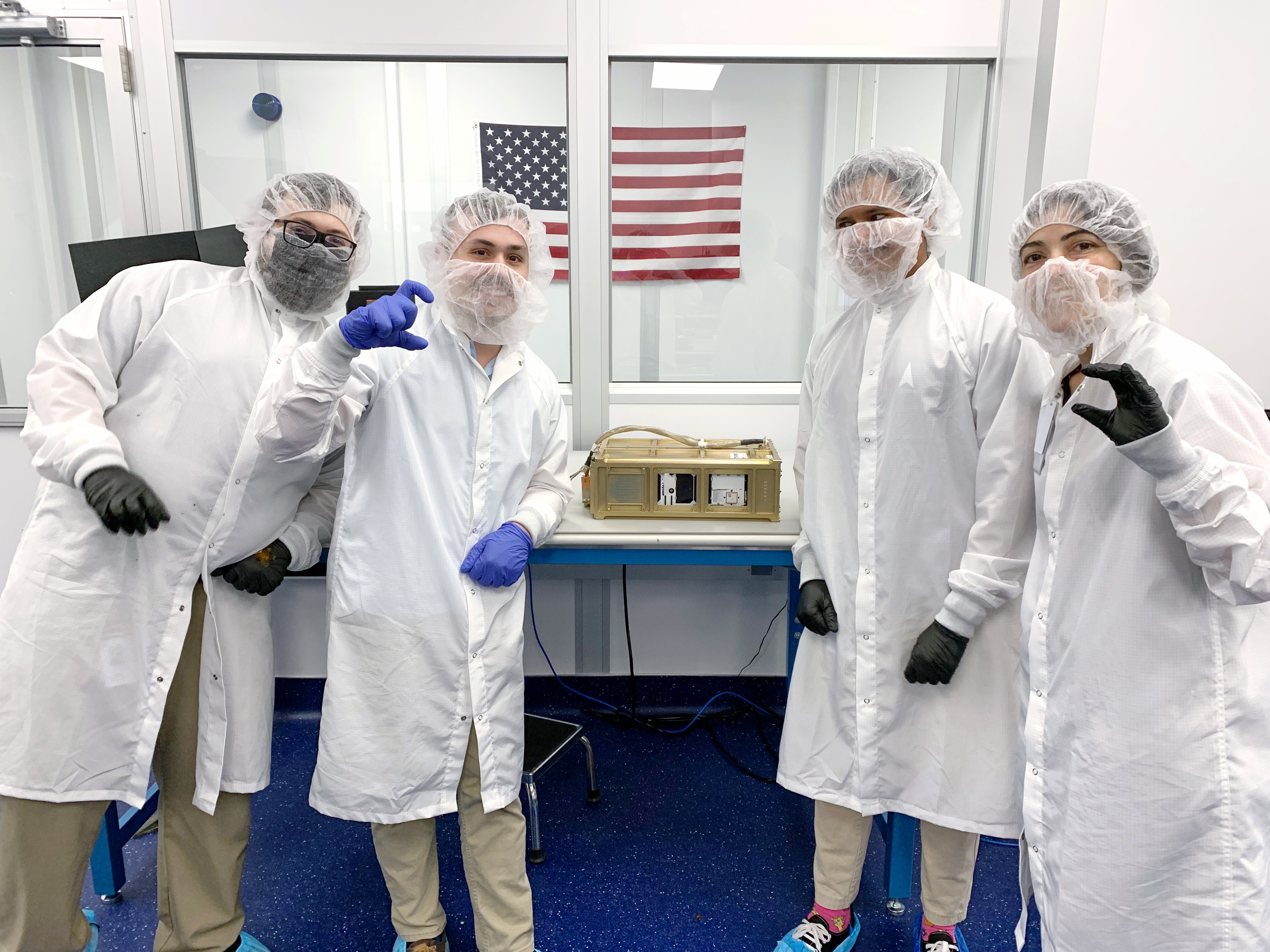 Four engineers from Terran Orbital Corporation pose with the CubeSat Proximity Operations and Demonstration (CPOD) spacecraft at their facility in ...