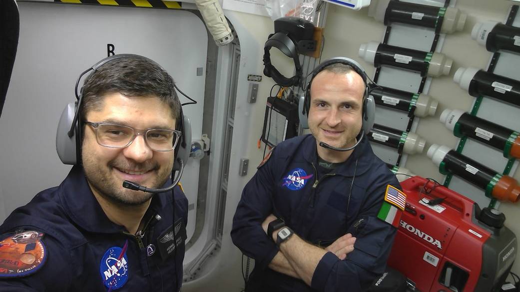 HERA crew members Dragos Michael Popescu and Pietro Di Tillio wear headsets to coordinate with others on a simulated Mars mission with communicatio...