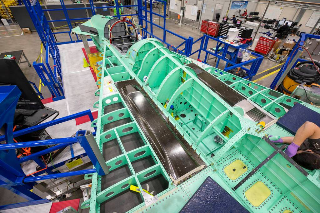 A technician performs work on the assembly of the X-59 wing section.